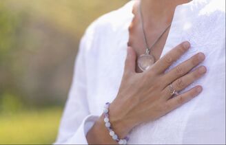 Woman holding a hand over her chest in contemplation Picture